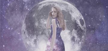 A young woman with blonde hair dressed in a purple dress stood in from of the moon and the expanse of space